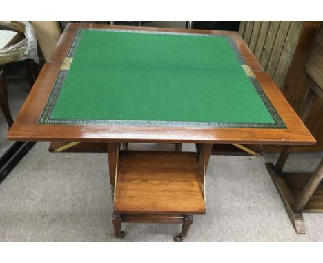 An Edwardian walnut card table with swivel top and pull out seats, on caster feet.Approx 38x76cm unextended