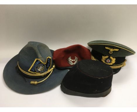 Four hats comprising a vintage GPO cap, a reproduction Nazi officer's hat and two others.
