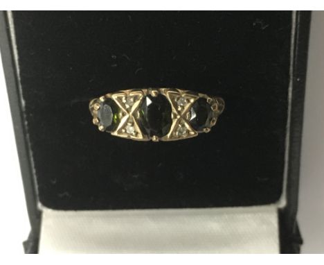 A 9ct gold ring set with three green stones.Approx P, 2.9g