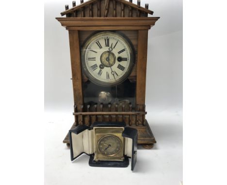 A small zenith brass travel clock in original case and a walnut case mantle clock striking on a bell .