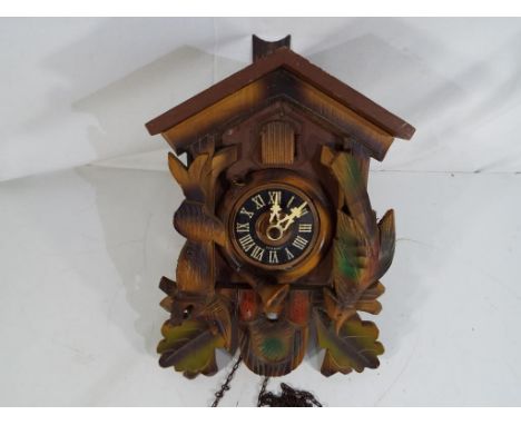 A German carved wood two weight cuckoo clock, Roman numerals to the dial, carved rabbit, bird and leaf decoration.