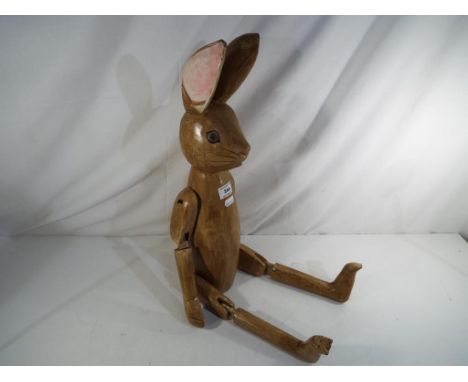 A large wooden shelf rabbit with jointed limbs Est £35 - £50