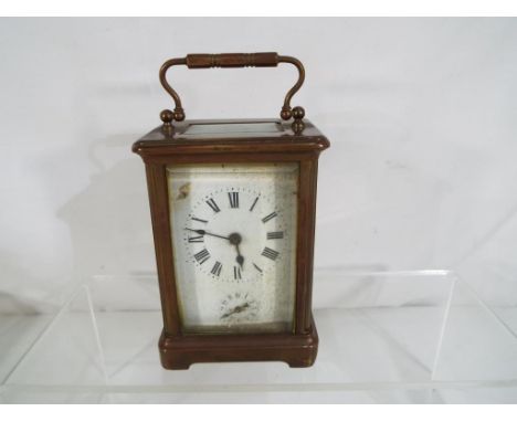 A French 8-day carriage clock, brass case with bevelled glasses, time and alarm feature, white enamel dial with Roman numeral