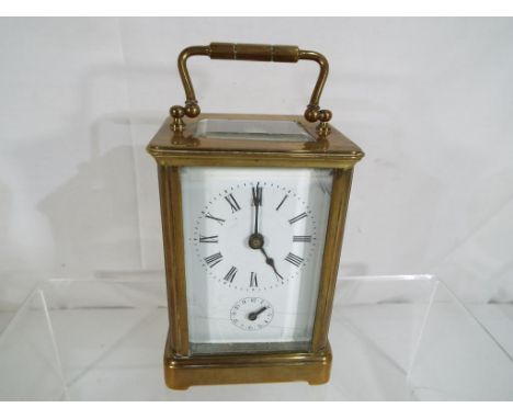 A good quality French 8-day carriage clock, brass case with bevelled glasses, time and alarm feature, white enamel dial with 