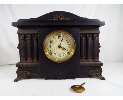 An ebonised case American mantel clock by Sessions, the case flanked by decorative columns and cast brass lions head mounts, 