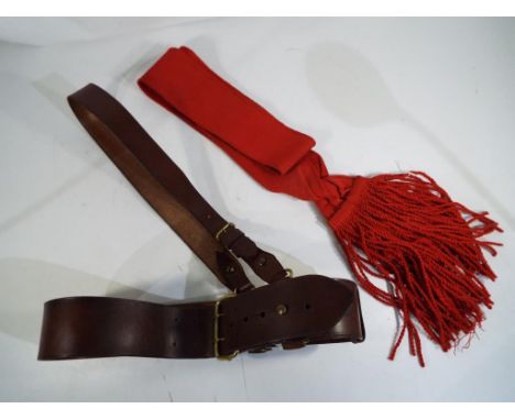 An officer's belt with shoulder strap and red sash. Estimate £25 - £35