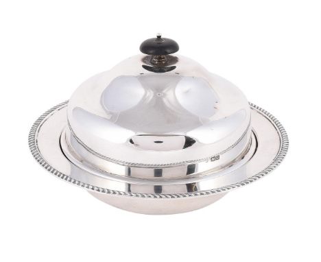 
	
		A SILVER MUFFIN DISH AND COVER
		WILLIAM HUTTON &amp; SONS LTD., SHEFFIELD 1916
		With a wooden domed finial to the ogee