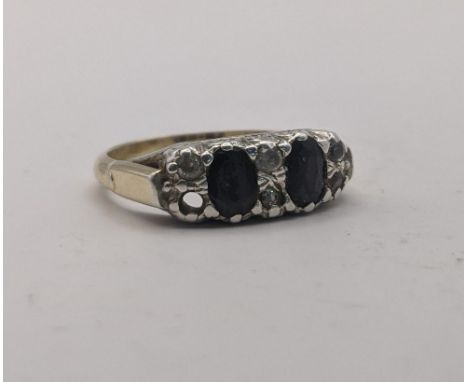 A yellow gold and silver set ring set with two black coloured stones between three vertical rows of smaller white stones, one