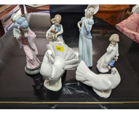 A group of Lladro and Nao porcelain figurines, along with two Lladro dove models, and a Japanese geisha girl figure with a fa