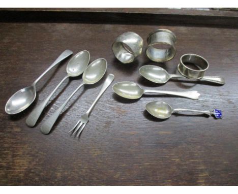 A group of silver items to include three napkin rings, six spoons, one with enamel decoration, and a small fork, mixed dates 