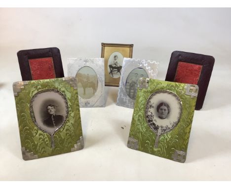 A collection of vintage photo frames. Including embossed leather, fabric with silver colour metal trim and others 