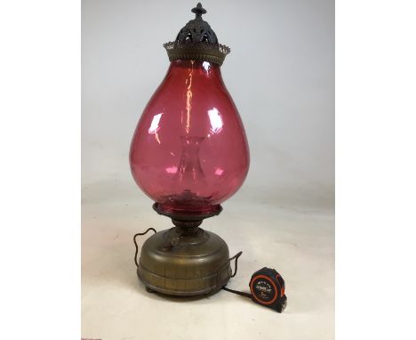 A very large early 20th century oil lamp with large cranberry shade and clear glass chimney. Manufactured by the Veritas lamp