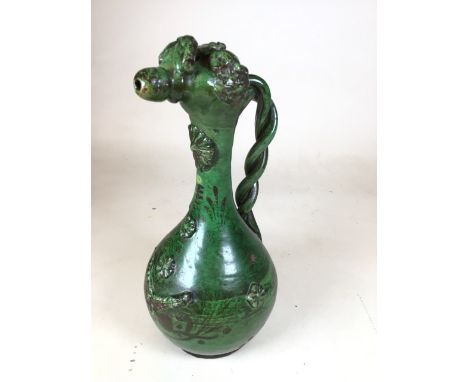 A green glazed Chanakkale (Western Turkey) pottery ewer, 19th century, with rope twisted handle and applied flower motifs dec
