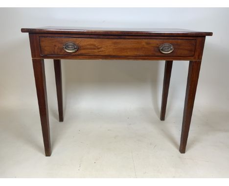 A Georgian mahogany side table with large central drawer and brass handles with fluted legs. W:92cm x D:50cm x H:74cm