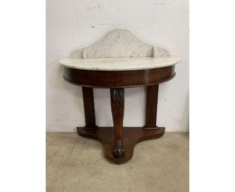 A Demi lune marbled topped console table with mahogany base and carved support. Crack to marble back. 