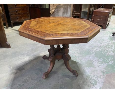 An inlaid walnut veneered octagonal table on ceramic castors 