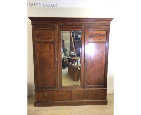 An Edwardian inlaid triple wardrobe with central mirror and two drawers to base. For restoration.W:190cm x D:50cm x H:210cm