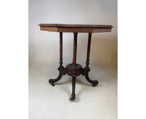 A Victorian octagonal inlaid walnut veneered occasional table with carved and turned legs to base on ceramic castors. W:65cm 