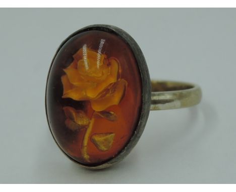 A lady's dress ring having a rose intaglio cabouchon panel in a yellow metal collared mount and loop, no marks,  tested as 9c