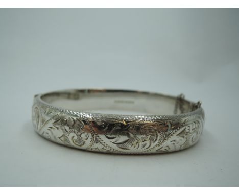A silver hinged bangle having engraved scroll decoration, approx 20.2g