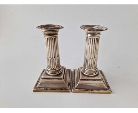 A pair of candlesticks with square beaded edge bases, detachable nozzles, 5" high, Sheffield 1897 by R&amp;B