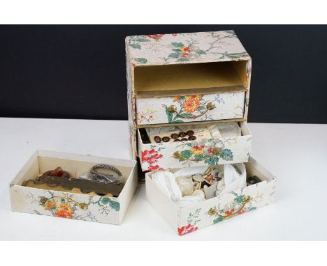 A collection of antique and vintage buttons and buckles contained within a four drawer storage case to include silver example