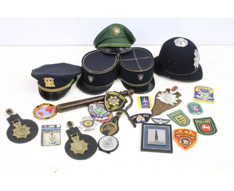 Assortment of vintage British and foreign Police collectables to include hats, wooden truncheon, stickers, badges, horse bras