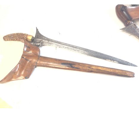 A good example of a 19th century Indonesian kris with waves edge Damascus type blade carved ivory handle and Rosewood scabbar