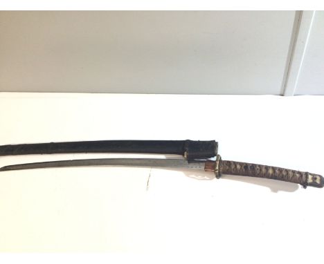 A Japanese II world war officers Samurai sword with a shagreen grip with woven cloth elaborate brass tsuba steel folded blade
