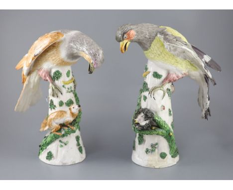 A pair of large German porcelain models of raptors, late 19th century, each seated upon a tree stump, one looking down at a n