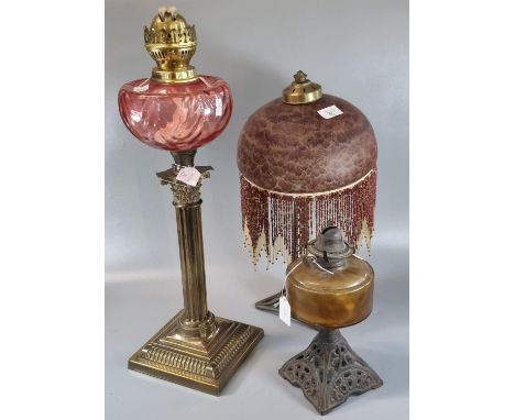 Early 20th century brass double burner oil lamp with cranberry reservoir and brass Corinthian column base.  56cm high approx.