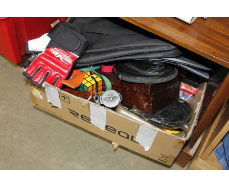 A box containing miscellaneous items including karate belts, Rubik Cube, compass etc.