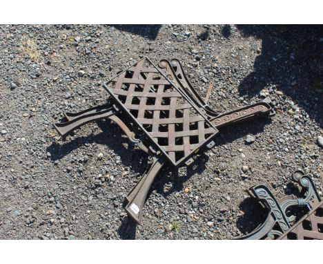 A pair of single seat cast iron bench ends and metal lattice effect backrest