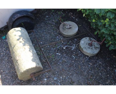 A cast iron and concrete garden roller; and two grinding wheels