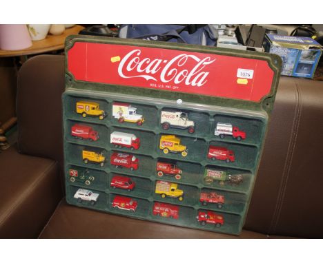 A collection of Coca-Cola model delivery vehicles in fitted case