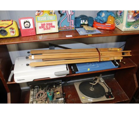 A folding artists easel, comb binder, and a paper cutter 