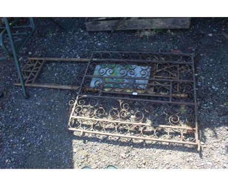 A wrought metal garden gate and a bamboo panel 