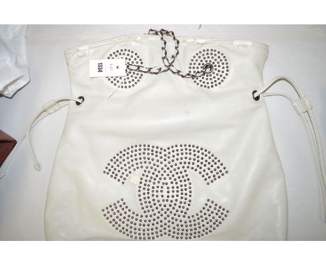 A light grey leather Chanel handbag with studded monogram, drawstring to body (distressed).