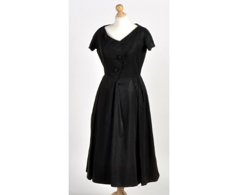 A Christian Dior 1950's black acetate cocktail dress, two buttons to front, zip to back, label reading "Christian Dior, Made 