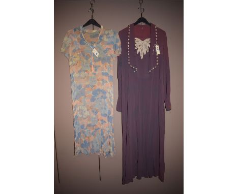 A 1920/30's silk day dress, blue and peach floral decoration; together with a similar period dress in purple crepe with centr