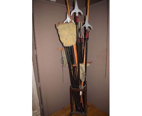 Theatre props, to include: spears and flags in a stained wood coat and stick stand.