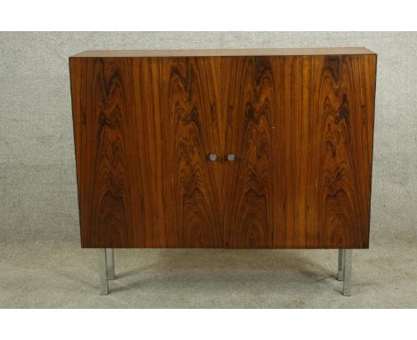 A vintage twin door hardwood cabinet raised on four square chrome plated supports. H.86 W.99cm. 