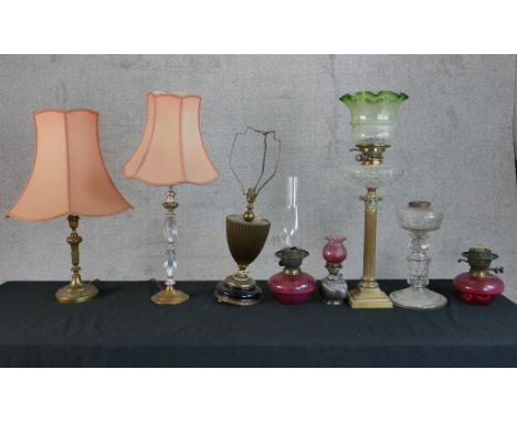 A 19th century brass Corinthian column oil lamp raised on square stepped base together with other lamps and parts of oil lamp