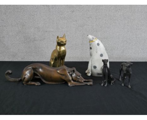 A 20th century patinated bronze figure of a crouching dog, together with two other dogs, a 20th century cast brass cat figure