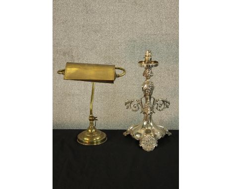 An early 20th century brass desk light together with a 20th century silver plated table lamp raised on four shell feet. H.43c