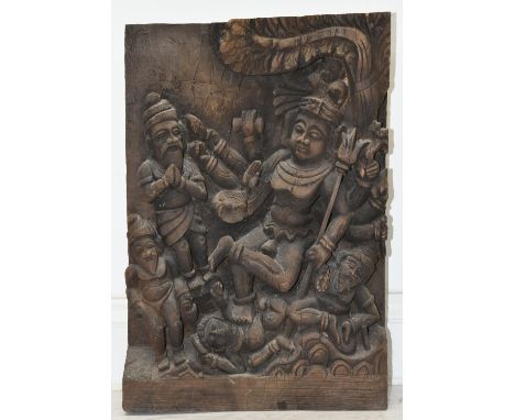 A carved South East Asian hardwood panel depicting a multi armed Bodhisattva with figures at his feet. H.50 W.33.5cm 