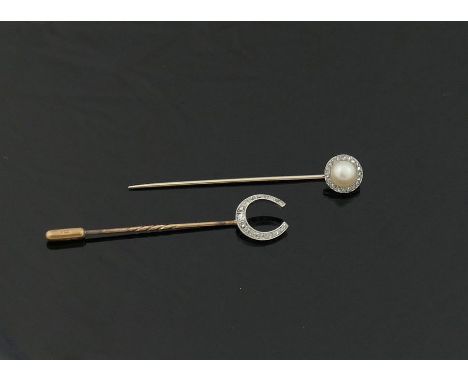 Two early 20th century stick pins, topped with a diamond set horseshoe, and a half pearl and diamond cluster, and three other