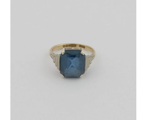 A 9 carat gold 1950's synthetic blue spinel single stone ring, the emerald cut stone set in white with Art Deco style stepped