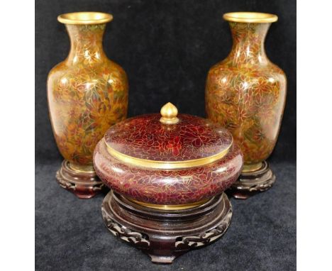 A pair of 20th century People's Republic of China cloisonné vases, and a similar lidded bowl, each with ebonised carved woode