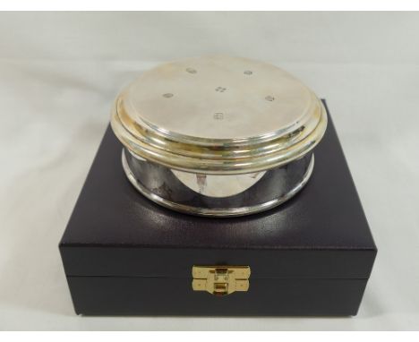 An Asprey and Co. circular silver trinket box, Sheffield 2001 with Millenium hallmark, the hallmarked hinged lid with stepped
